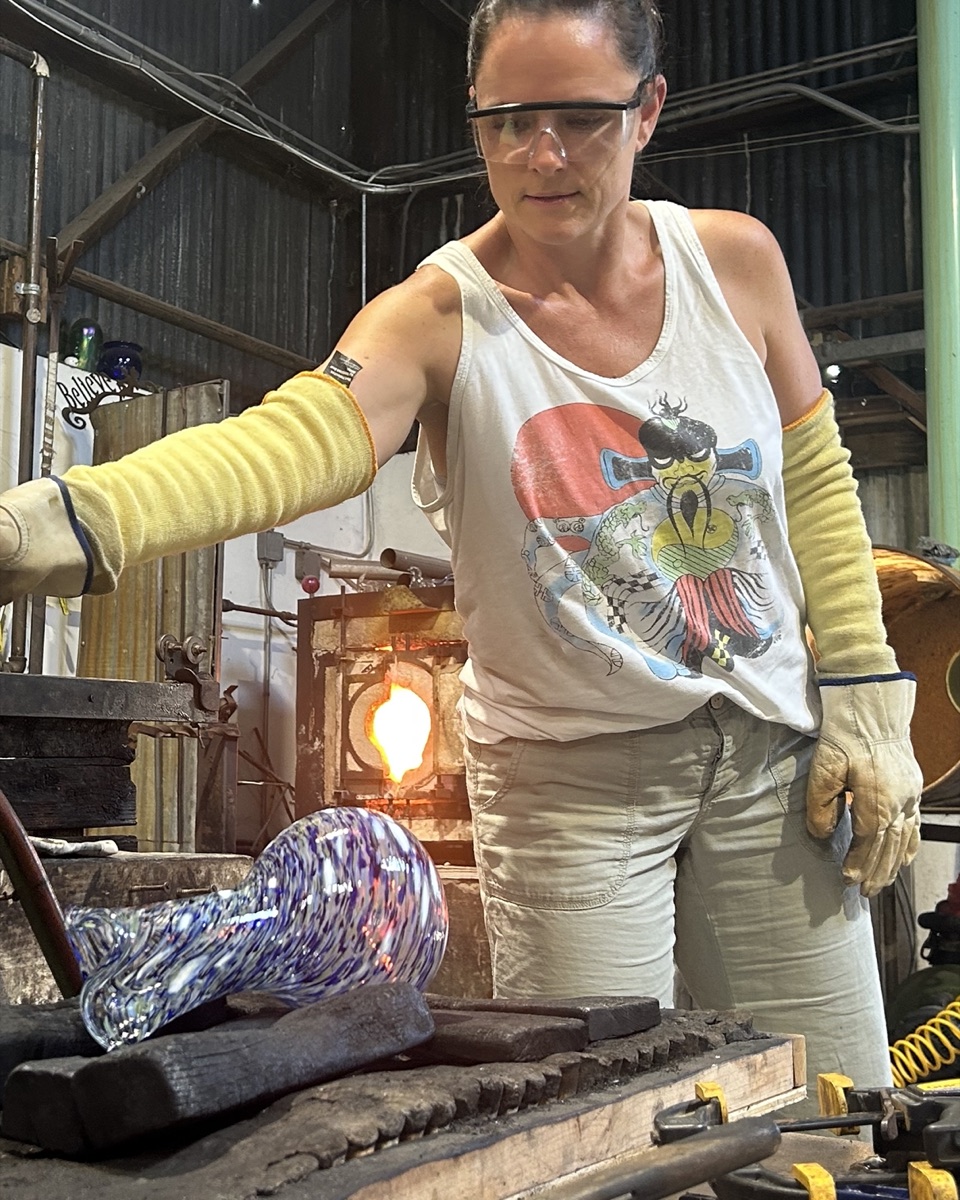 Erin working with molten glass at a glassblowing studio
